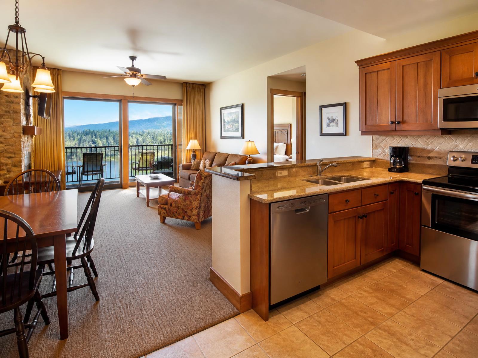 Spacious resort condominium with a full kitchen, dining table and balcony overlooking a mountain lake
